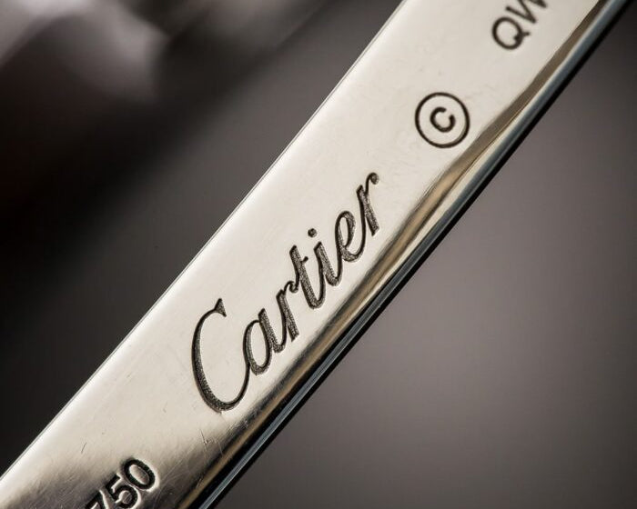 Close-up image of a hallmark stamp on a piece of 18 karat gold jewelry, clearly visible.