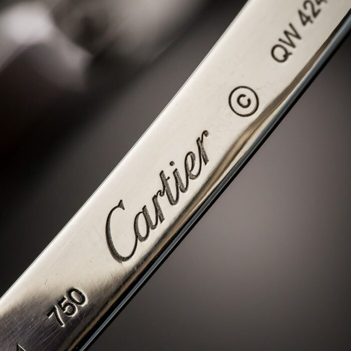 Close-up image of a hallmark stamp on a piece of 18 karat gold jewelry, clearly visible.