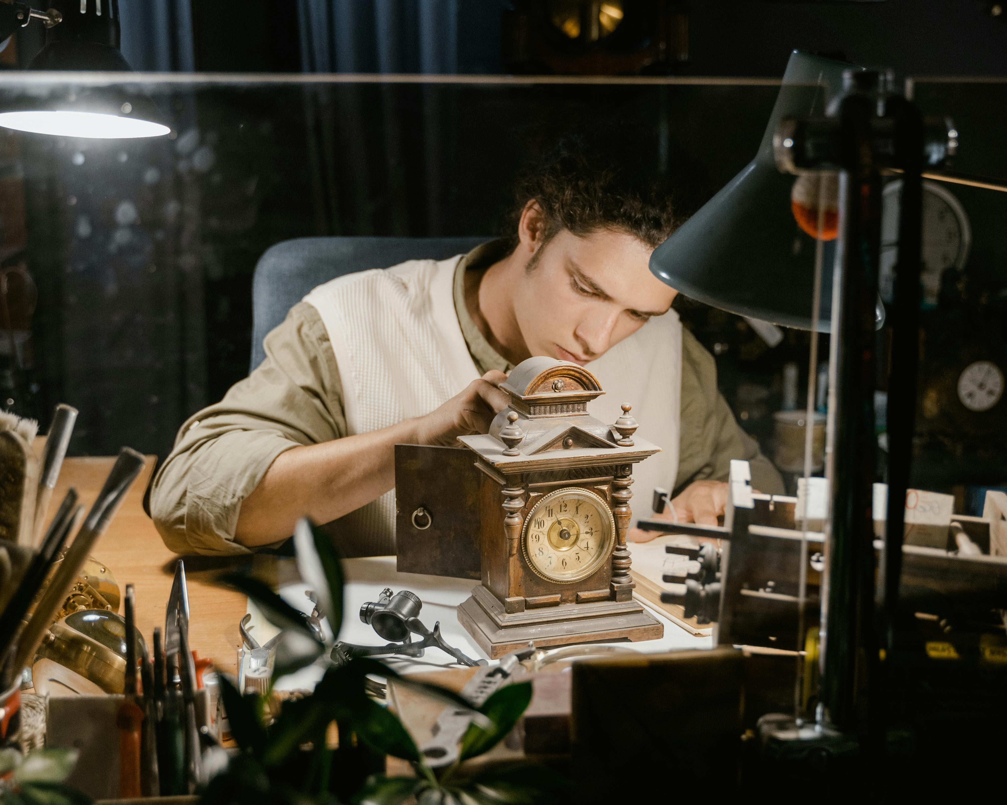 Image of a jeweler in a private consultation setting, leaning over a desk with a client, sketches, and loose gems, emphasizing personal interaction