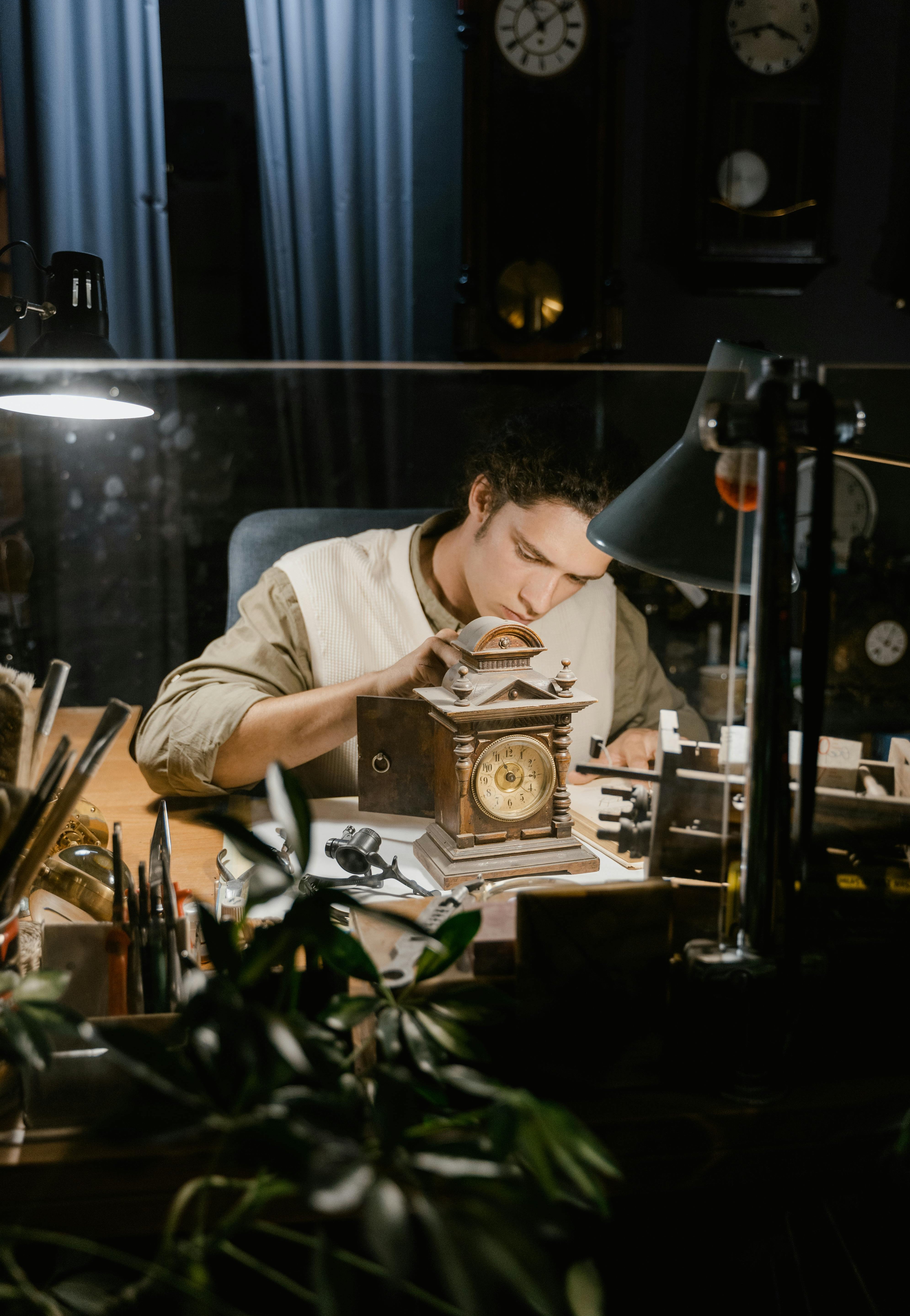 Image of a jeweler in a private consultation setting, leaning over a desk with a client, sketches, and loose gems, emphasizing personal interaction